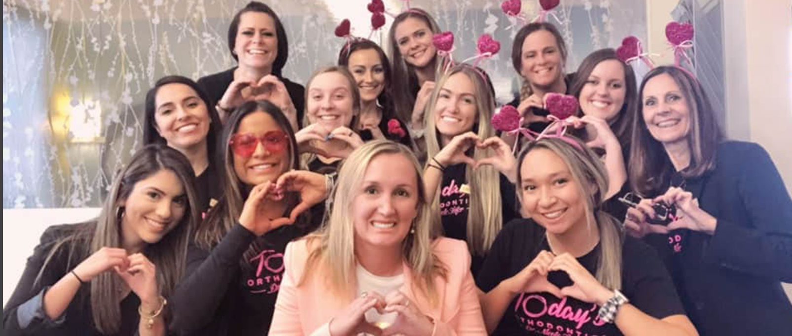 Today's Ortho Team smiling and holding up heart signs with hands