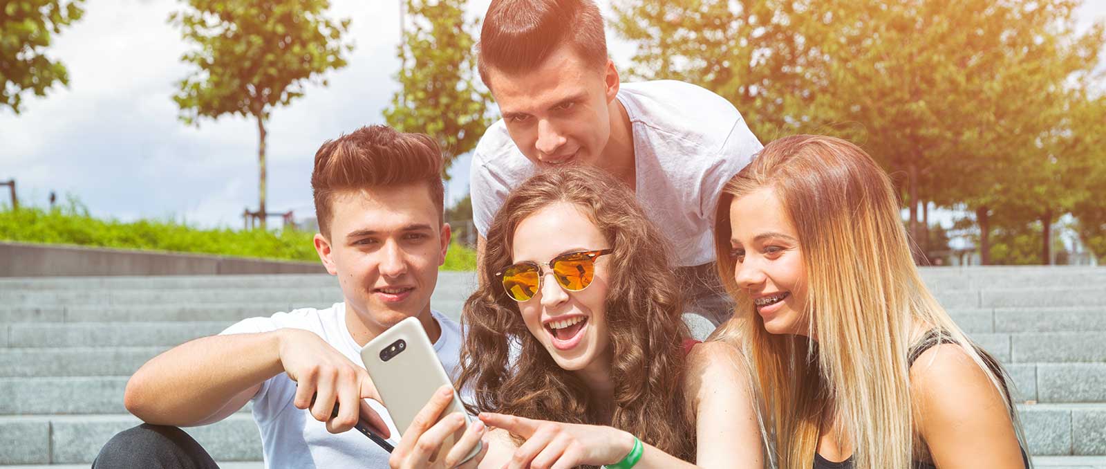 Teens looking at a phone smiling