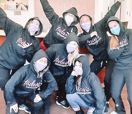 Today's Ortho Team wearing hoodies with company logo and masks